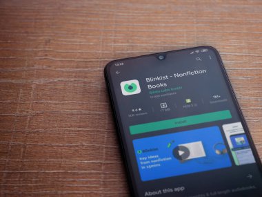 Lod, Israel - 8 Temmuz 2020: Blinkist uygulama oyun mağazası sayfası ahşap arka planda siyah bir cep telefonu ekranında. Üst görünüm düzlüğü kopyalama alanı ile yatıyordu.