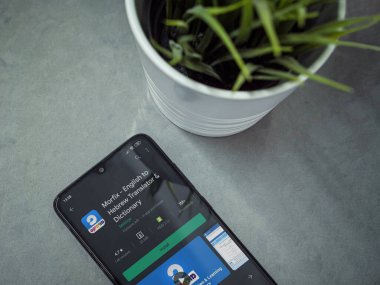 Lod, Israel - 8 Temmuz 2020: Mermer arka planda Morfix uygulaması oyun mağazası sayfası olan siyah cep telefonlu modern minimalist ofis çalışma alanı. Üst görünüm yatağını kapat.