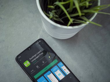 Lod, Israel - 8 Temmuz 2020: Duolingo 'lu siyah cep telefonlu modern minimalist ofis çalışma alanı - Mermer bir arka planda uygulama oyunu sayfası. Üst görünüm yatağını kapat.