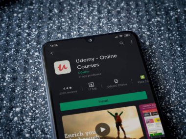 Lod, Israel - 8 Temmuz 2020: Metalik arka planda siyah bir cep telefonunun ekranında Udemy uygulaması oyun mağazası sayfası. Üst görünüm yatağını kapat. 