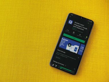 Lod, Israel - 8 Temmuz 2020: Quizlet - Dil öğrenme uygulaması oyun mağazası sayfası sarı kumaş arka planda siyah bir cep telefonu ekranında. Üst görünüm düzlüğü kopyalama alanı ile yatıyordu.