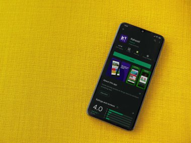 Lod, Israel - 8 Temmuz 2020: Kahoot! Uygulama oyun mağazası sayfası sarı kumaş arka planda siyah bir cep telefonunun ekranında. Üst görünüm düzlüğü kopyalama alanı ile yatıyordu.