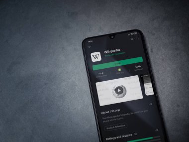 Lod, Israel - 8 Temmuz 2020: Wikipedia uygulama oyun mağazası sayfası koyu mermer taştan bir arka planda siyah bir cep telefonu ekranında. Üst görünüm düzlüğü kopyalama alanı ile yatıyordu.