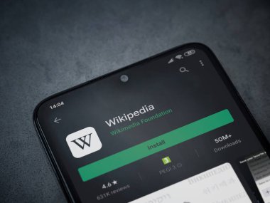 Lod, Israel - 8 Temmuz 2020: Wikipedia uygulama oyun mağazası sayfası koyu mermer taştan bir arka planda siyah bir cep telefonu ekranında. Üst görünüm düzlüğü kopyalama alanı ile yatıyordu.