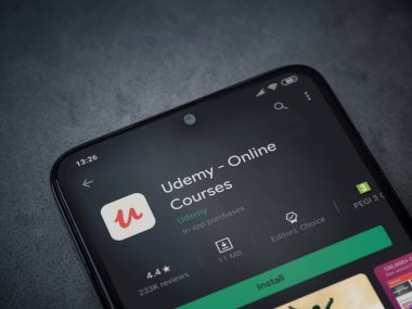 Lod, Israel - 8 Temmuz 2020: Udemy uygulaması oyun mağazası sayfası koyu mermer taştan arka planda siyah bir cep telefonunun ekranında. Üst görünüm düzlüğü kopyalama alanı ile yatıyordu.