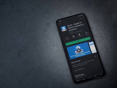 Lod, Israel - 8 Temmuz 2020: Morfix uygulaması oyun mağazası sayfası koyu mermer taştan arka planda siyah bir cep telefonunun ekranında. Üst görünüm düzlüğü kopyalama alanı ile yatıyordu.