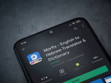 Lod, Israel - 8 Temmuz 2020: Morfix uygulaması oyun mağazası sayfası koyu mermer taştan arka planda siyah bir cep telefonunun ekranında. Üst görünüm düzlüğü kopyalama alanı ile yatıyordu.