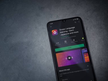 Lod, Israel - 8 Temmuz 2020: Drops - Dil öğrenme uygulaması oyun mağazası sayfası koyu mermer taştan bir arka planda siyah bir cep telefonu ekranında. Üst görünüm düzlüğü kopyalama alanı ile yatıyordu.