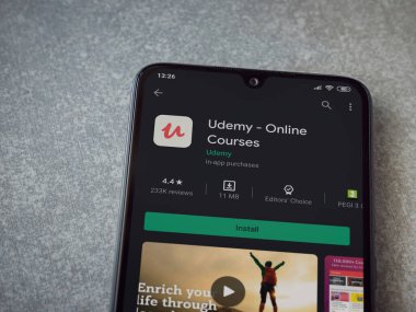 Lod, Israel - 8 Temmuz 2020: Seramik taş zemin üzerinde siyah bir cep telefonunun sergilendiği Udemy uygulaması oyun mağazası sayfası. Üst görünüm düzlüğü kopyalama alanı ile yatıyordu.