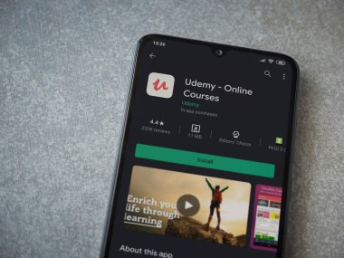 Lod, Israel - 8 Temmuz 2020: Seramik taş zemin üzerinde siyah bir cep telefonunun sergilendiği Udemy uygulaması oyun mağazası sayfası. Üst görünüm düzlüğü kopyalama alanı ile yatıyordu.