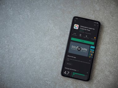 Lod, Israel - 8 Temmuz 2020: SoloLearn - Seramik taş zemin üzerinde siyah bir cep telefonunun ekranında kodlama uygulaması oyun mağazası sayfasını öğrenme. Üst görünüm düzlüğü kopyalama alanı ile yatıyordu.