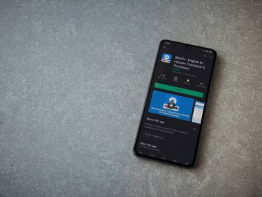 Lod, Israel - 8 Temmuz 2020: Morfix uygulaması oyun mağazası sayfası seramik taş zemin üzerinde siyah bir cep telefonu görüntüsü. Üst görünüm düzlüğü kopyalama alanı ile yatıyordu.