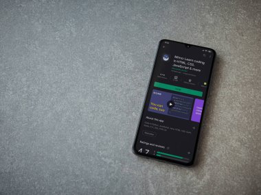 Lod, Israel - 8 Temmuz 2020: Mimo - Seramik taş zemin üzerinde siyah bir cep telefonunun ekranında kodlama uygulaması oyun mağazası sayfasını öğreniyor. Üst görünüm düzlüğü kopyalama alanı ile yatıyordu.