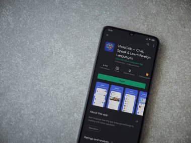 Lod, Israel - 8 Temmuz 2020: HelloTalk - Seramik taş zemin üzerinde siyah bir cep telefonunun gösterildiği uygulama oyun mağazası sayfası. Üst görünüm düzlüğü kopyalama alanı ile yatıyordu.
