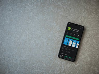 Lod, Israel - 8 Temmuz 2020: Duolingo - Seramik taş zemin üzerinde siyah bir cep telefonunun sergilendiği uygulama oyun mağazası sayfası. Üst görünüm düzlüğü kopyalama alanı ile yatıyordu.