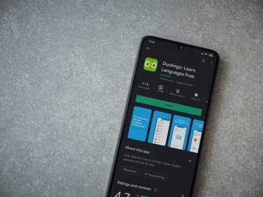 Lod, Israel - 8 Temmuz 2020: Duolingo - Seramik taş zemin üzerinde siyah bir cep telefonunun sergilendiği uygulama oyun mağazası sayfası. Üst görünüm düzlüğü kopyalama alanı ile yatıyordu.