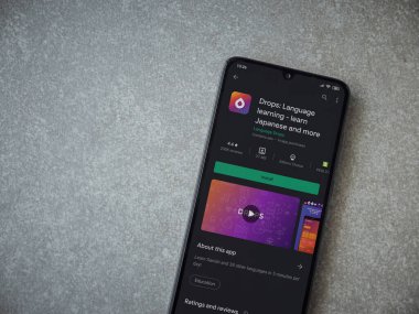 Lod, Israel - 8 Temmuz 2020: Damlalar - Seramik taş zemin üzerinde siyah bir cep telefonu ekranında dil öğrenme uygulaması oyun mağazası sayfası. Üst görünüm düzlüğü kopyalama alanı ile yatıyordu.