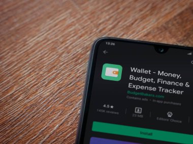 Lod, Israel - 8 Temmuz 2020: Cüzdan uygulaması oyun mağazası sayfası ahşap arka planda siyah bir cep telefonu ekranında. Üst görünüm düzlüğü kopyalama alanı ile yatıyordu.