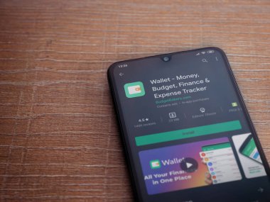 Lod, Israel - 8 Temmuz 2020: Cüzdan uygulaması oyun mağazası sayfası ahşap arka planda siyah bir cep telefonu ekranında. Üst görünüm düzlüğü kopyalama alanı ile yatıyordu.