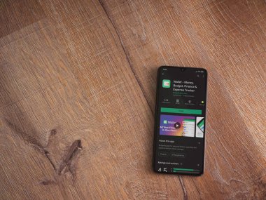 Lod, Israel - 8 Temmuz 2020: Cüzdan uygulaması oyun mağazası sayfası ahşap arka planda siyah bir cep telefonu ekranında. Üst görünüm düzlüğü kopyalama alanı ile yatıyordu.