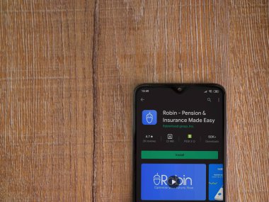 Lod, Israel - 8 Temmuz 2020: Robin uygulama oyun mağazası sayfası ahşap arka planda siyah bir cep telefonunun ekranında. Üst görünüm düzlüğü kopyalama alanı ile yatıyordu.