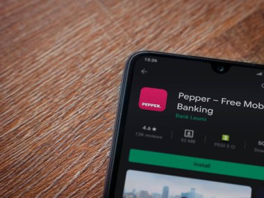 Lod, Israel - 8 Temmuz 2020: Biber uygulaması oyun mağazası sayfası ahşap arka planda siyah bir cep telefonunun ekranında. Üst görünüm düzlüğü kopyalama alanı ile yatıyordu.