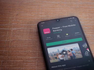 Lod, Israel - 8 Temmuz 2020: Biber uygulaması oyun mağazası sayfası ahşap arka planda siyah bir cep telefonunun ekranında. Üst görünüm düzlüğü kopyalama alanı ile yatıyordu.