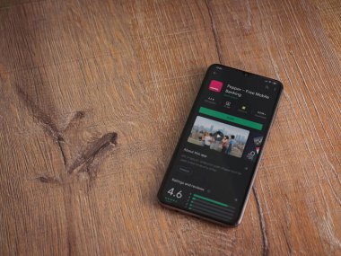 Lod, Israel - 8 Temmuz 2020: Biber uygulaması oyun mağazası sayfası ahşap arka planda siyah bir cep telefonunun ekranında. Üst görünüm düzlüğü kopyalama alanı ile yatıyordu.