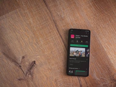 Lod, Israel - 8 Temmuz 2020: Biber uygulaması oyun mağazası sayfası ahşap arka planda siyah bir cep telefonunun ekranında. Üst görünüm düzlüğü kopyalama alanı ile yatıyordu.