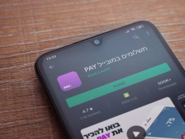 Lod, Israel - 8 Temmuz 2020: Öde uygulaması oyun mağazası sayfası ahşap arka planda siyah bir cep telefonunun ekranında. Üst görünüm düzlüğü kopyalama alanı ile yatıyordu.