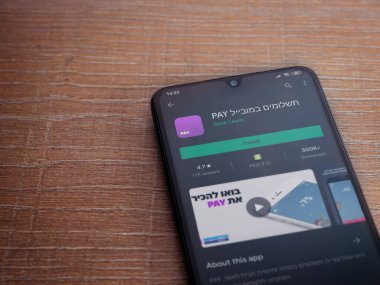 Lod, Israel - 8 Temmuz 2020: Öde uygulaması oyun mağazası sayfası ahşap arka planda siyah bir cep telefonunun ekranında. Üst görünüm düzlüğü kopyalama alanı ile yatıyordu.