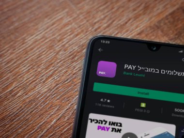 Lod, Israel - 8 Temmuz 2020: Öde uygulaması oyun mağazası sayfası ahşap arka planda siyah bir cep telefonunun ekranında. Üst görünüm düzlüğü kopyalama alanı ile yatıyordu.