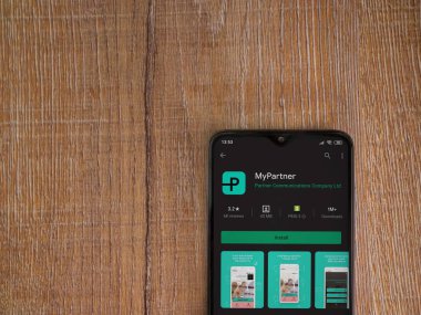 Lod, Israel - 8 Temmuz 2020: Partner Uygulama Oyun Mağazası sayfam ahşap arka planda siyah bir cep telefonunun ekranında. Üst görünüm düzlüğü kopyalama alanı ile yatıyordu.