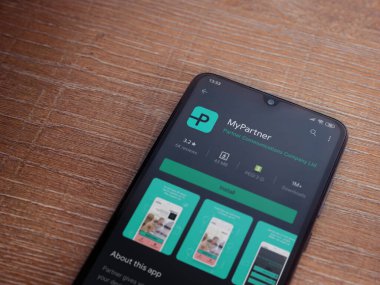 Lod, Israel - 8 Temmuz 2020: Partner Uygulama Oyun Mağazası sayfam ahşap arka planda siyah bir cep telefonunun ekranında. Üst görünüm düzlüğü kopyalama alanı ile yatıyordu.