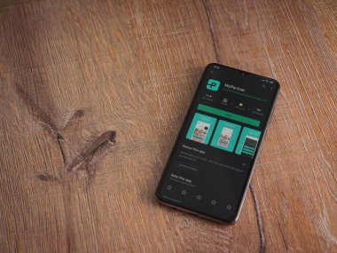 Lod, Israel - 8 Temmuz 2020: Partner Uygulama Oyun Mağazası sayfam ahşap arka planda siyah bir cep telefonunun ekranında. Üst görünüm düzlüğü kopyalama alanı ile yatıyordu.