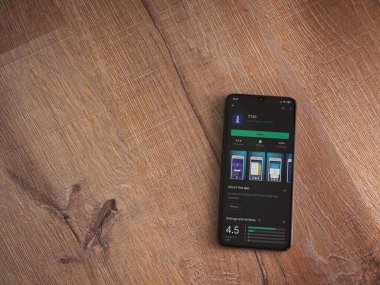 Lod, Israel - 8 Temmuz 2020: Gögdal uygulama oyun mağazası sayfası ahşap arka planda siyah bir cep telefonunun ekranında. Üst görünüm düzlüğü kopyalama alanı ile yatıyordu.