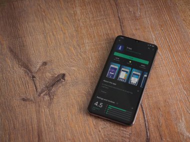 Lod, Israel - 8 Temmuz 2020: Gögdal uygulama oyun mağazası sayfası ahşap arka planda siyah bir cep telefonunun ekranında. Üst görünüm düzlüğü kopyalama alanı ile yatıyordu.