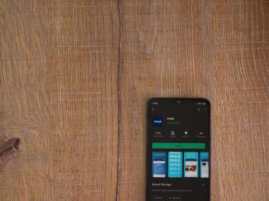 Lod, Israel - 8 Temmuz 2020: Max app oyun mağazası sayfası ahşap arka planda siyah bir cep telefonunun ekranında. Üst görünüm düzlüğü kopyalama alanı ile yatıyordu.