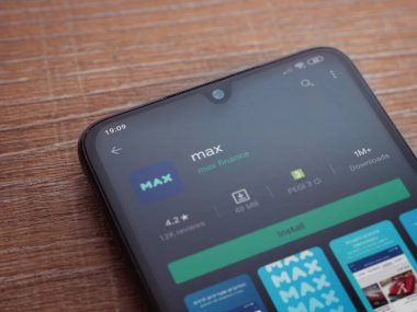 Lod, Israel - 8 Temmuz 2020: Max app oyun mağazası sayfası ahşap arka planda siyah bir cep telefonunun ekranında. Üst görünüm düzlüğü kopyalama alanı ile yatıyordu.