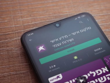 Lod, Israel - 8 Temmuz 2020: Cep telefonu uygulaması oyun mağazası sayfası ahşap arka planda siyah bir cep telefonunun ekranında. Üst görünüm düzlüğü kopyalama alanı ile yatıyordu.