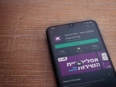 Lod, Israel - 8 Temmuz 2020: Cep telefonu uygulaması oyun mağazası sayfası ahşap arka planda siyah bir cep telefonunun ekranında. Üst görünüm düzlüğü kopyalama alanı ile yatıyordu.