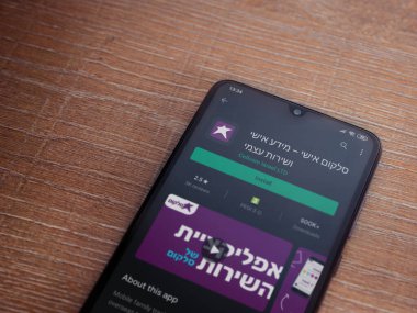 Lod, Israel - 8 Temmuz 2020: Cep telefonu uygulaması oyun mağazası sayfası ahşap arka planda siyah bir cep telefonunun ekranında. Üst görünüm düzlüğü kopyalama alanı ile yatıyordu.