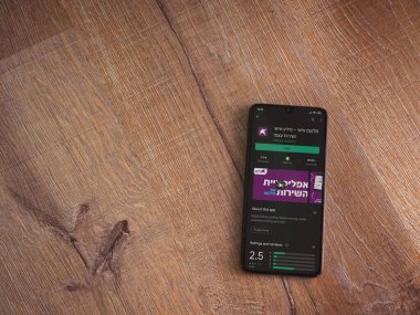 Lod, Israel - 8 Temmuz 2020: Cep telefonu uygulaması oyun mağazası sayfası ahşap arka planda siyah bir cep telefonunun ekranında. Üst görünüm düzlüğü kopyalama alanı ile yatıyordu.