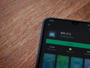 Lod, Israel - 8 Temmuz 2020: Ahşap arka planda siyah bir cep telefonunun ekranında bit uygulaması oyun mağazası sayfası. Üst görünüm düzlüğü kopyalama alanı ile yatıyordu.