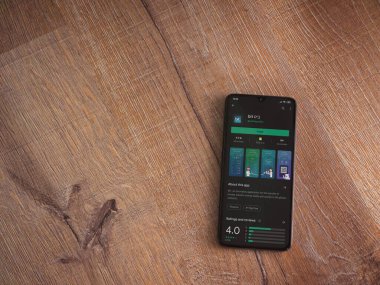 Lod, Israel - 8 Temmuz 2020: Ahşap arka planda siyah bir cep telefonunun ekranında bit uygulaması oyun mağazası sayfası. Üst görünüm düzlüğü kopyalama alanı ile yatıyordu.