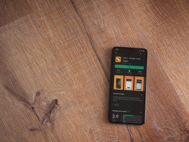 Lod, Israel - 8 Temmuz 2020: Bank Mizrahi Tefahot uygulaması oyun mağazası sayfası ahşap arka planda siyah bir cep telefonu sergilenmektedir. Üst görünüm düzlüğü kopyalama alanı ile yatıyordu.