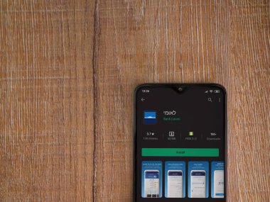 Lod, Israel - 8 Temmuz 2020: Bank Leumi uygulama oyun mağazası sayfası ahşap arka planda siyah bir cep telefonu ekranında. Üst görünüm düzlüğü kopyalama alanı ile yatıyordu.