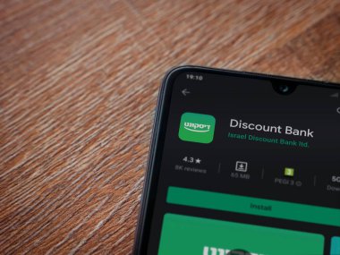 Lod, Israel - 8 Temmuz 2020: Banka İndirim uygulaması oyun mağazası sayfası ahşap arka planda siyah bir cep telefonunun ekranında. Üst görünüm düzlüğü kopyalama alanı ile yatıyordu.