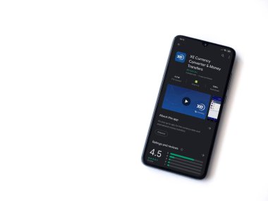 Lod, Israel - 8 Temmuz 2020: XE Para Birimi uygulaması oyun mağazası sayfası beyaz arkaplanda izole edilmiş siyah bir cep telefonu ekranında. Üst görünüm düzlüğü kopyalama alanı ile yatıyordu.