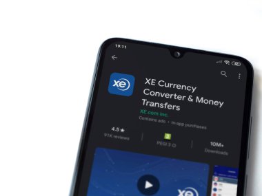 Lod, Israel - 8 Temmuz 2020: XE Para Birimi uygulaması oyun mağazası sayfası beyaz arkaplanda izole edilmiş siyah bir cep telefonu ekranında. Üst görünüm düzlüğü kopyalama alanı ile yatıyordu.